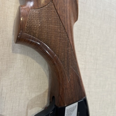 Coronha de madeira castanha com empunhadura curva e detalhe em metal negro com gravação