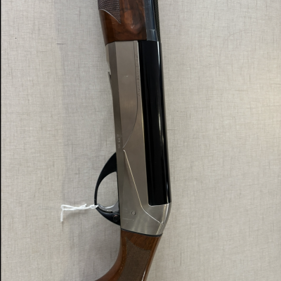 Espingarda de caça com coronha em madeira e cano preto, sobre fundo bege