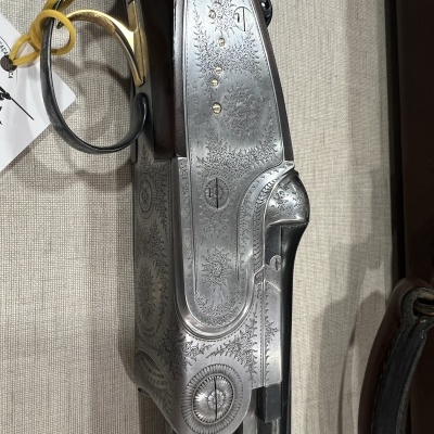 Espingarda de canos duplos com corpo prateado entalhado e punho madeira castanha