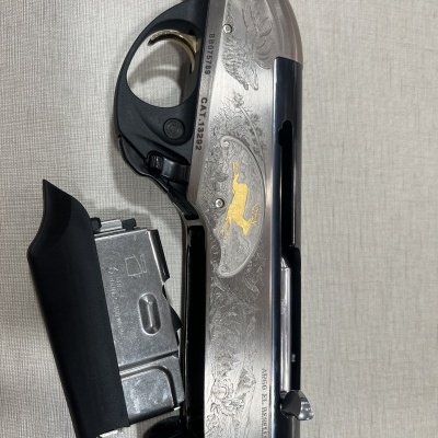 arma de fogo com cabo de madeira e corpo metálico gravado