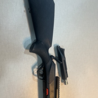 Espingarda preta com cano removível sobre fundo claro