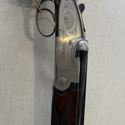 Espingarda de caça com metal gravado e empunhadura de madeira escura