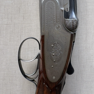 Espingarda com cabo de madeira castanha e parte metálica prateada gravada