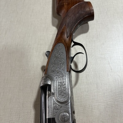 Espingarda de canos duplos com coronha em madeira e metal gravado