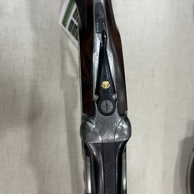 Espingarda em madeira e metal com detalhes gravados e símbolo dourado