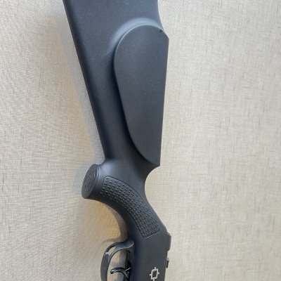 Espingarda de cano duplo preta com punho texturizado num fundo bege