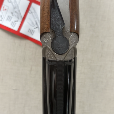 Arma de caça com detalhes em madeira e metal gravado