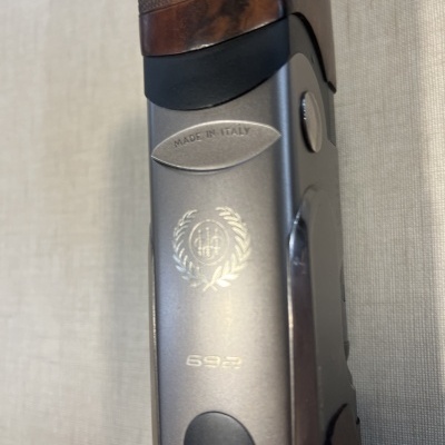 Arma de fogo com empunhadura em madeira e metal com inscrições e emblema