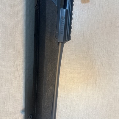 Arma de fogo preta com inscrição BERETTA em tecido claro