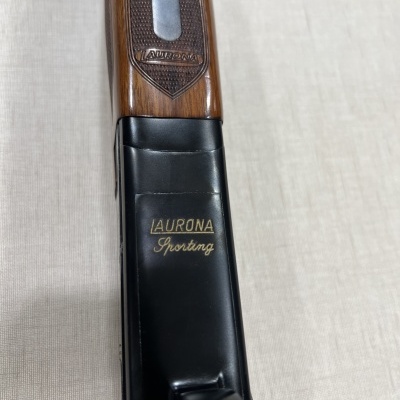 Espingarda com gravação Laurona Sporting em madeira e metal preto.