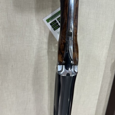 Espingarda com cabo de madeira castanha e cano metálico brilhante