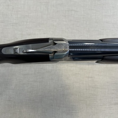 Espingarda de caça de canos duplos vista de cima sobre tecido bege