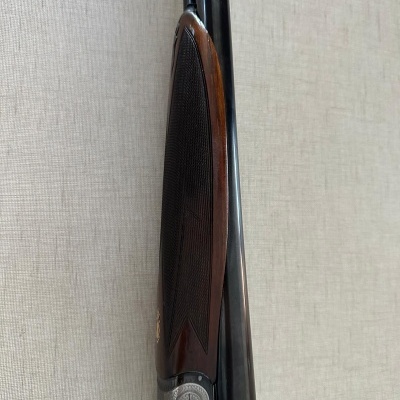 Espingarda de canos paralelos com empunhadura em madeira castanha e detalhes em metal prateado