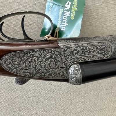 Espingarda com gravações florais no metal e coronha de madeira escura