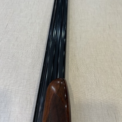 Espingarda com canos duplos pretos e empunhadura de madeira