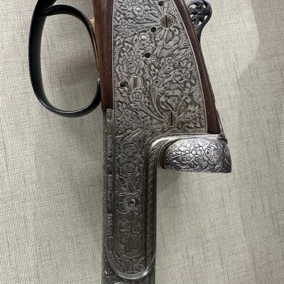 Rifle artesanal com detalhes gravados em metal e madeira