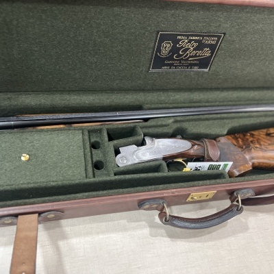 Espingarda de caça desdobrável com coronha de madeira numa caixa verde