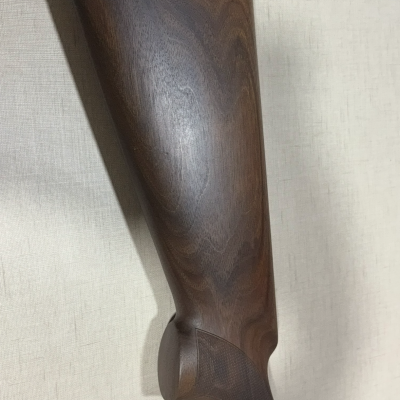 Espaço traseiro de arma de caça ou tiro em madeira castanha escura com calcanhar preto.