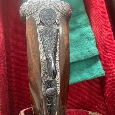 Espingarda com punho em madeira e metais gravados em estojo vermelho