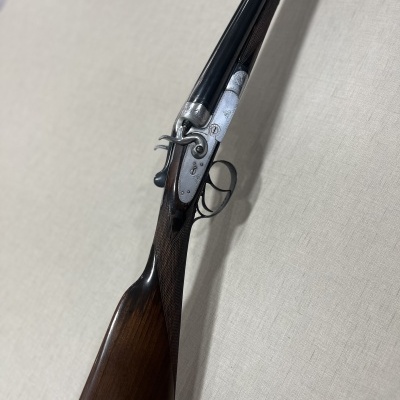 Espingarda de caça com coronha em madeira e canos metálicos pretos