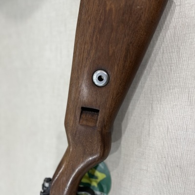 Coronha de espingarda em madeira castanha com detalhe metálico