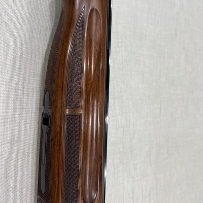 Arma de fogo com empunhadura em madeira e cano metal preto