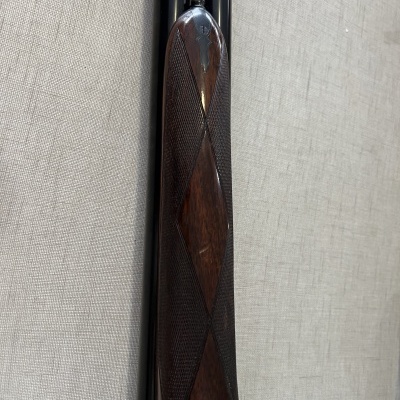 Arma de fogo com canos duplos e empunhadura de madeira texturizada