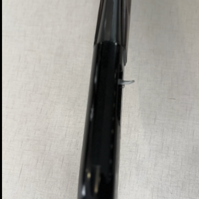 Parte superior de objeto preto brilhante sobre tecido claro