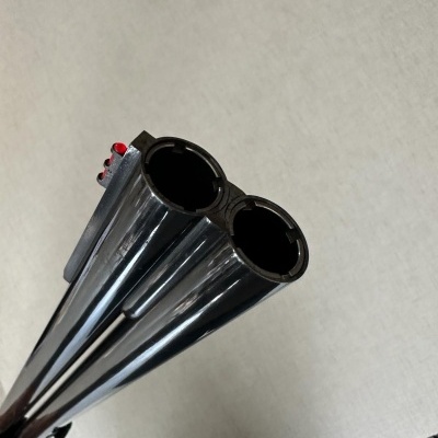 Canos duplos paralelos de arma metálica brilhante com mira vermelha na extremidade