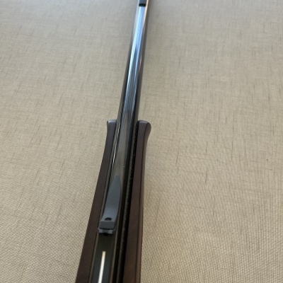 Cabo de arma de fogo de madeira e metal sobre fundo bege