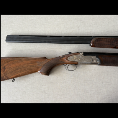 Espingarda canos duplos com coronha em madeira e detalhes metálicos gravados