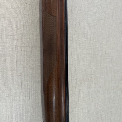 Parte de espingarda com madeira castanha escura e cano preto