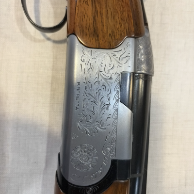 Parte central de uma espingarda com cabo de madeira e corpo metálico gravado