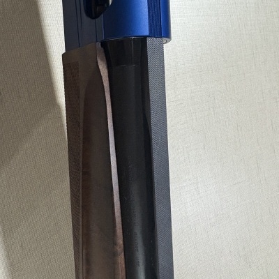 Parte de arma de fogo com coronha madeira, cano preto e parte superior azul