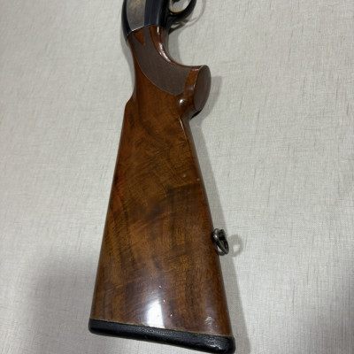 Espingarda com coronha de madeira polida e armação metálica preta