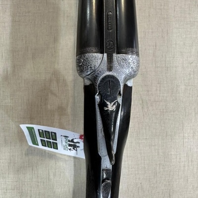 Espingarda Beretta com canos duplos e detalhes metálicos gravados