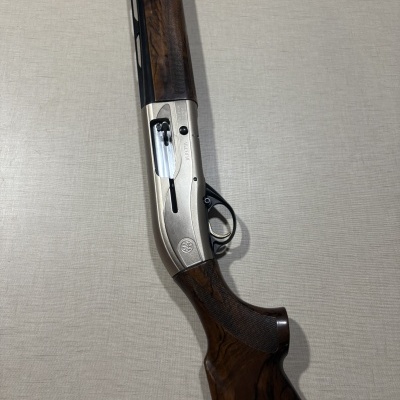 Espingarda Beretta com detalhes em madeira castanha e metal prateado