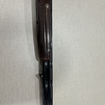 Espingarda de cano duplo com acabamento em madeira castanha escura e metal preto