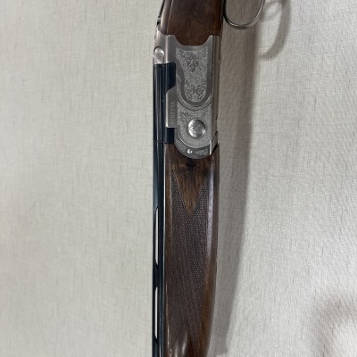 Espingarda de canos duplos com empunhadura de madeira e armação metálica gravada