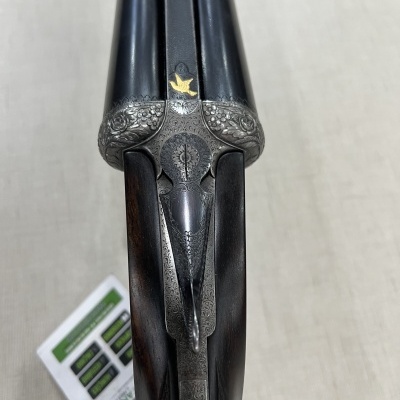 Espingarda de canos duplos com punho em madeira e detalhes decorativos