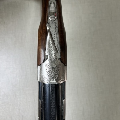 Espingarda com madeira castanha e partes metálicas prateadas gravadas