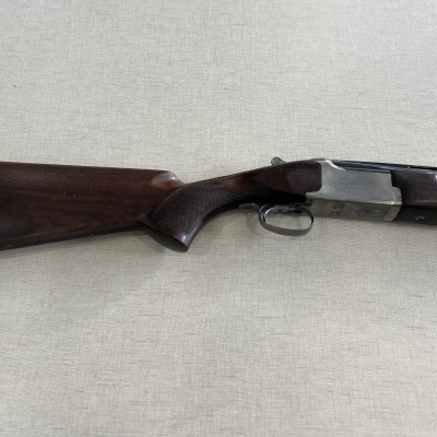 Espingarda com coronha de madeira escura e metal prateado