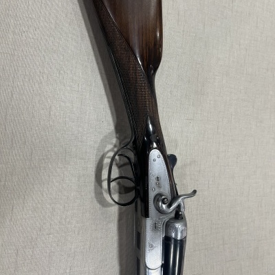 Espingarda de canos paralelos com acabamento em metal e madeira escura