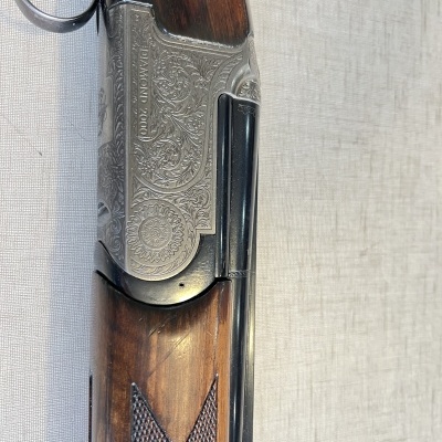 Espingarda de canos paralelos com empunhadura em madeira e caixa metálica gravada