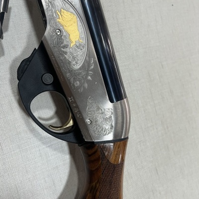 Espingarda com cabo de madeira e desenhos metálicos gravados