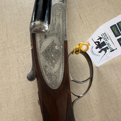 Espingarda de caça em madeira e metal com etiqueta pendurada