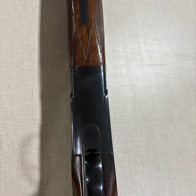 Parte superior de espingarda com madeira castanha e metal preto