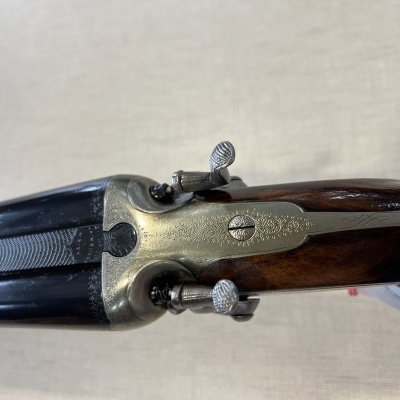 Espingarda dupla cano curto com corpo metálico e coronha de madeira