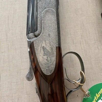 Arma de fogo cano longo com detalhes em madeira e metal e marcador verde pendurado