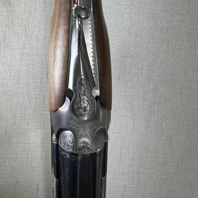 Espingarda com detalhes metálicos gravados e coronha de madeira castanha